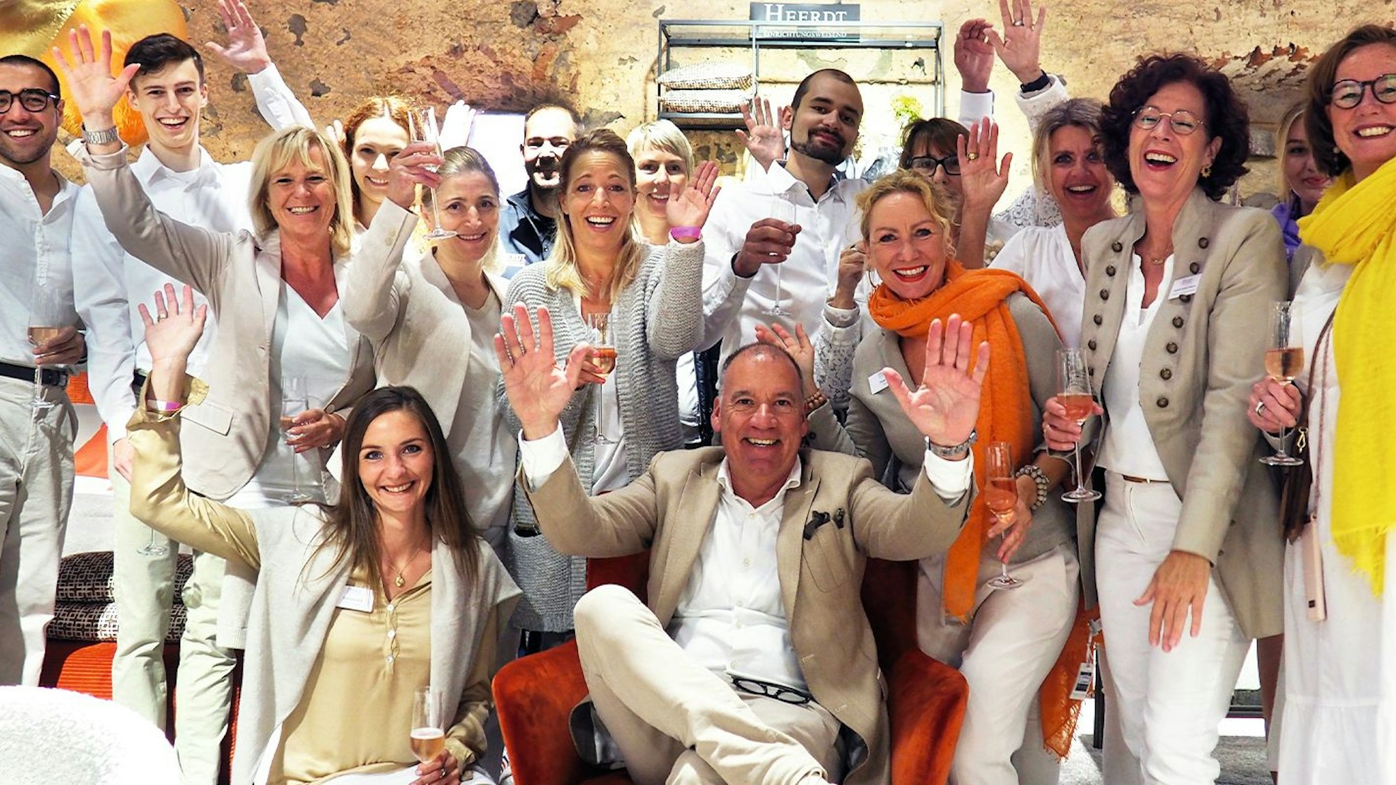 Das Foto zeigt die Mitarbeitenden des Einrichtungshauses in Jubelpose.