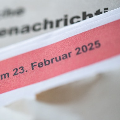 Eine geöffnete amtliche Wahlbenachrichtigung zur Wahl zum Deutschen Bundestag am 23. Februar 2025 liegt auf einem Tisch.