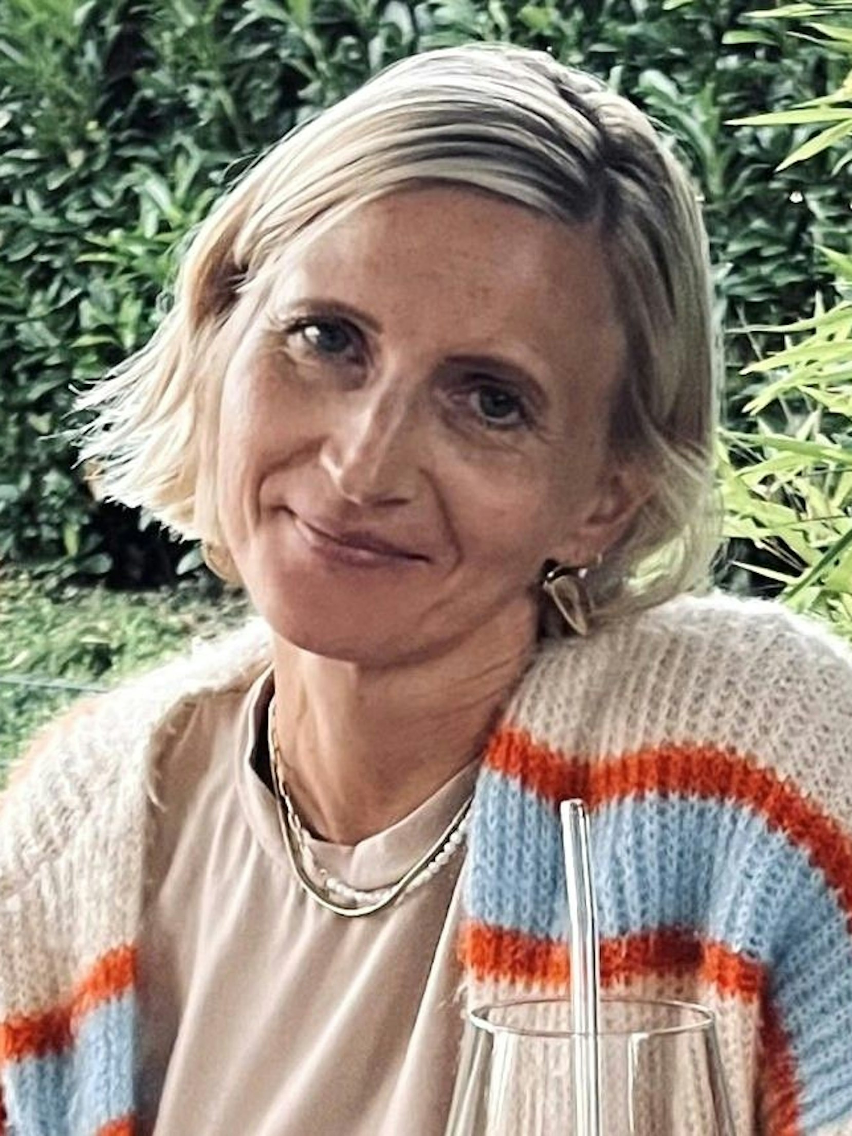 Eine blonde Frau lächelt.