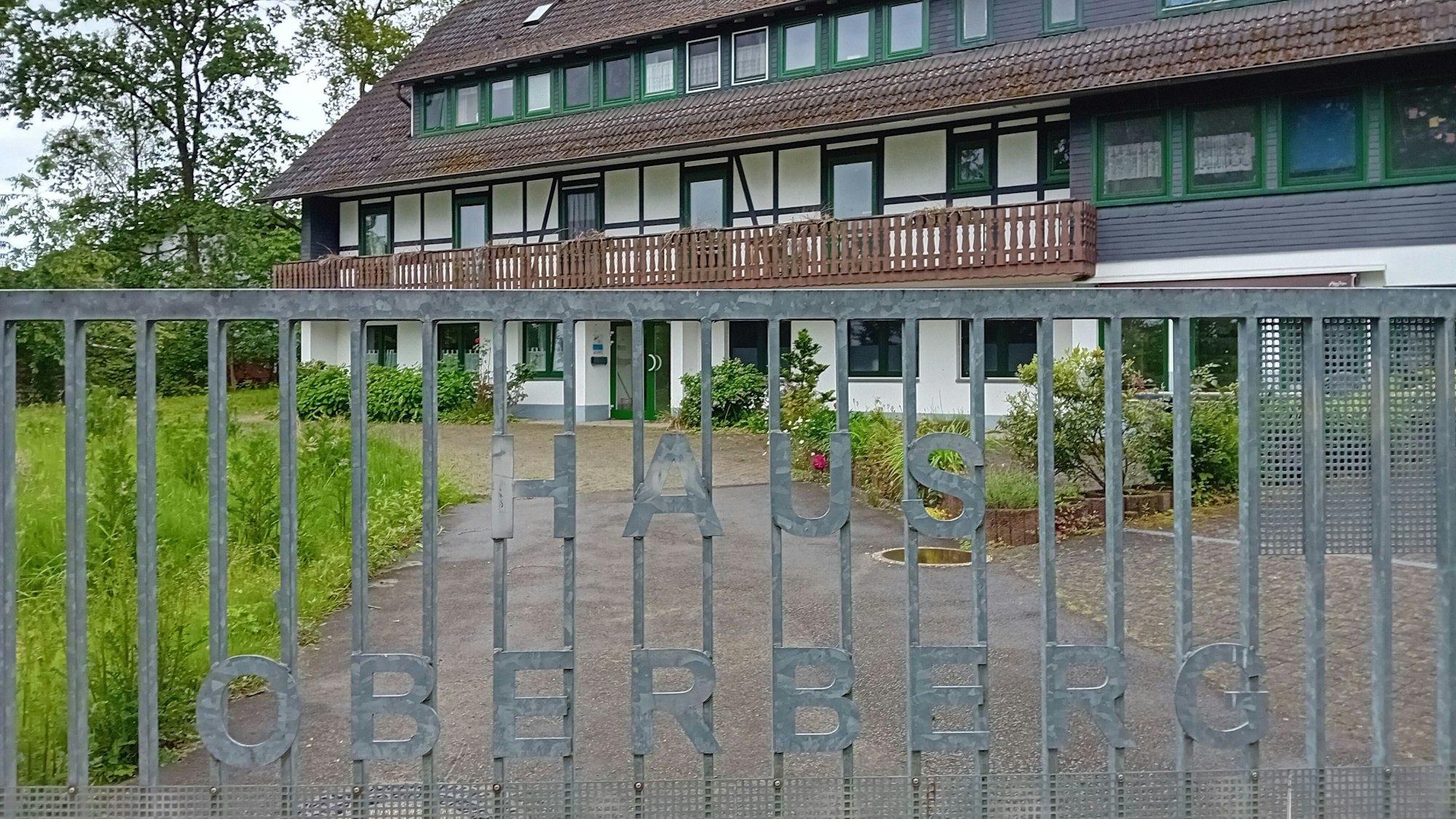 Ein Haus hinter einem Gatter mit der Aufschrift „Haus Oberberg“.