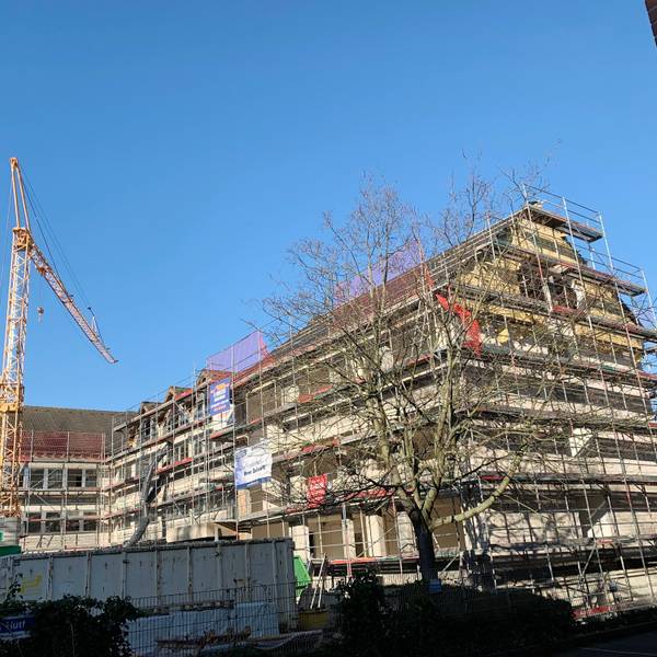 Das dreieinhalbgeschossige Gebäude in Euskirchen ist eingerüstet, auf dem Vorplatz steht ein Baukran.