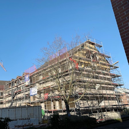 Das dreieinhalbgeschossige Gebäude in Euskirchen ist eingerüstet, auf dem Vorplatz steht ein Baukran.