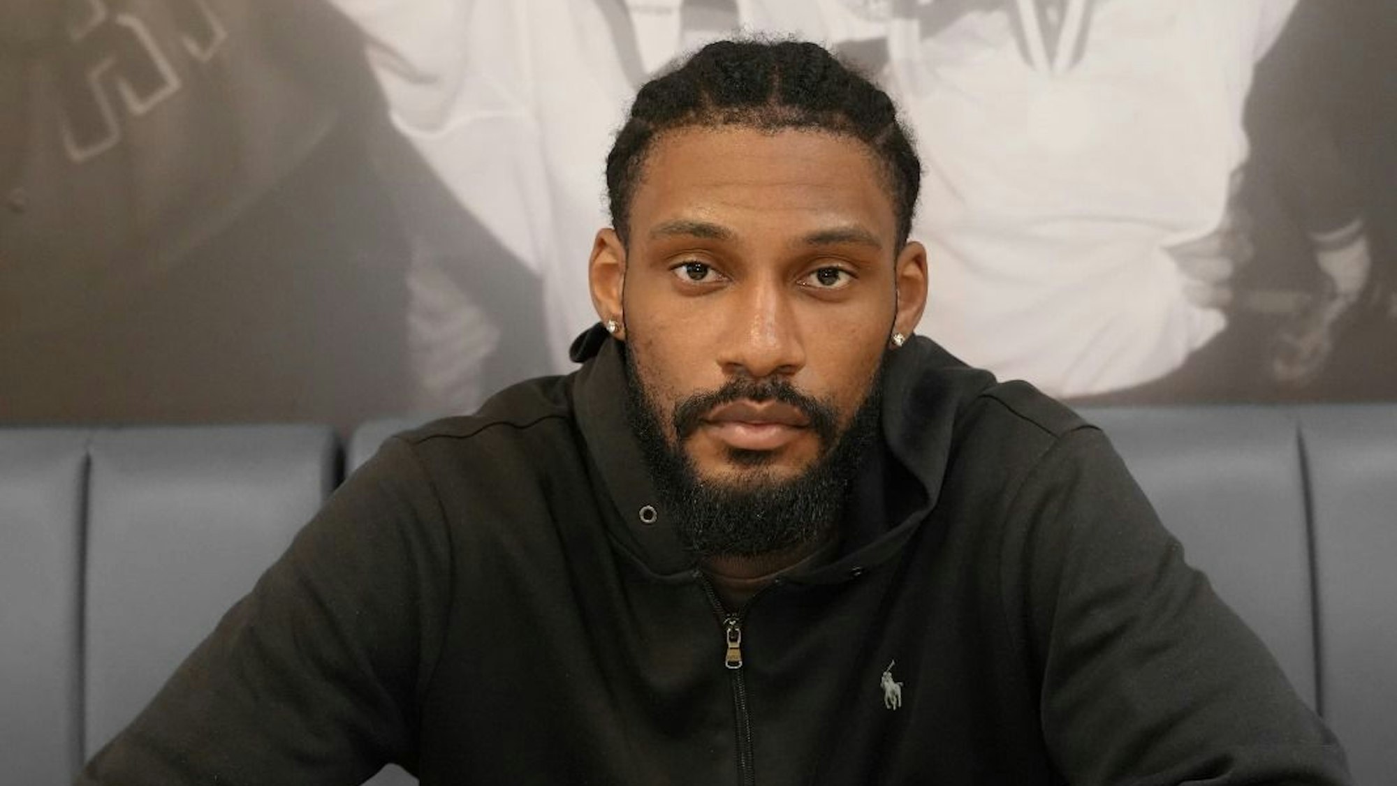 Dominic Duncan sitzt an einem Tisch und unterschreibt seinen Vertrag.