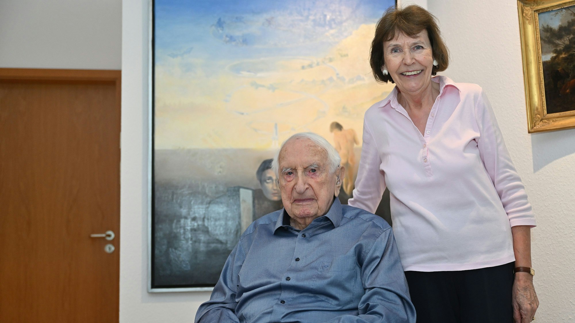 Heinrich J. Jarczyk und seine Ehefrau Christiane Jarczyk posieren vor einem Gemälde.