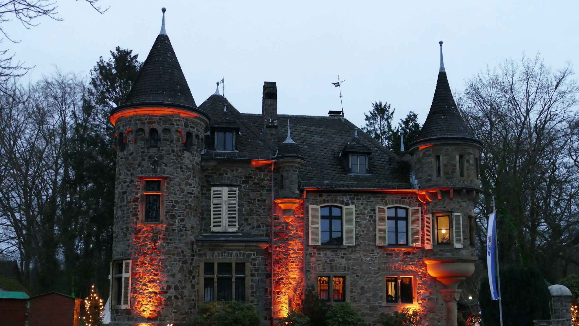 Eine angestrahlte Burg mit zwei Türmen.