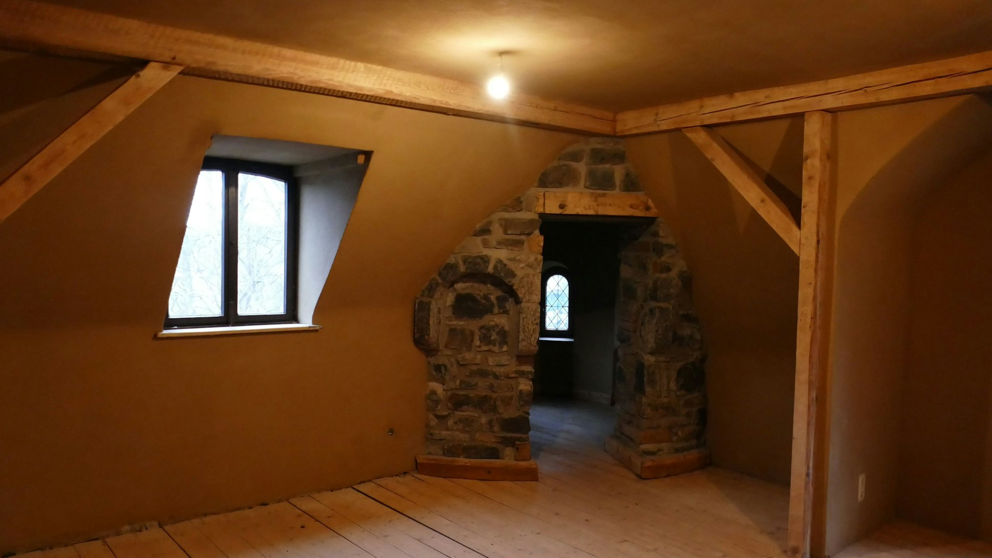 Ein Raum, in dessen Ecke das alte Mauerwerk zu sehen ist.