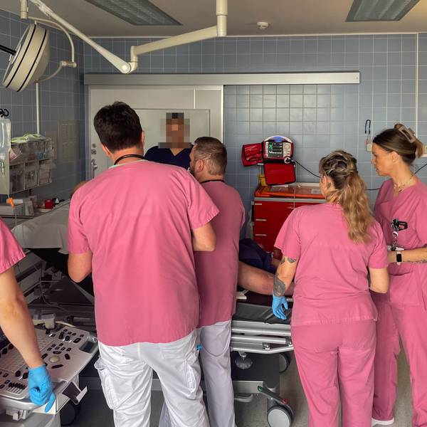 Mitarbeiter der Zentralen Notaufnahme des Marien-Hospitals in Euskirchen in rosafarbener Arbeitskleidung kümmern sich um einen Patienten.
