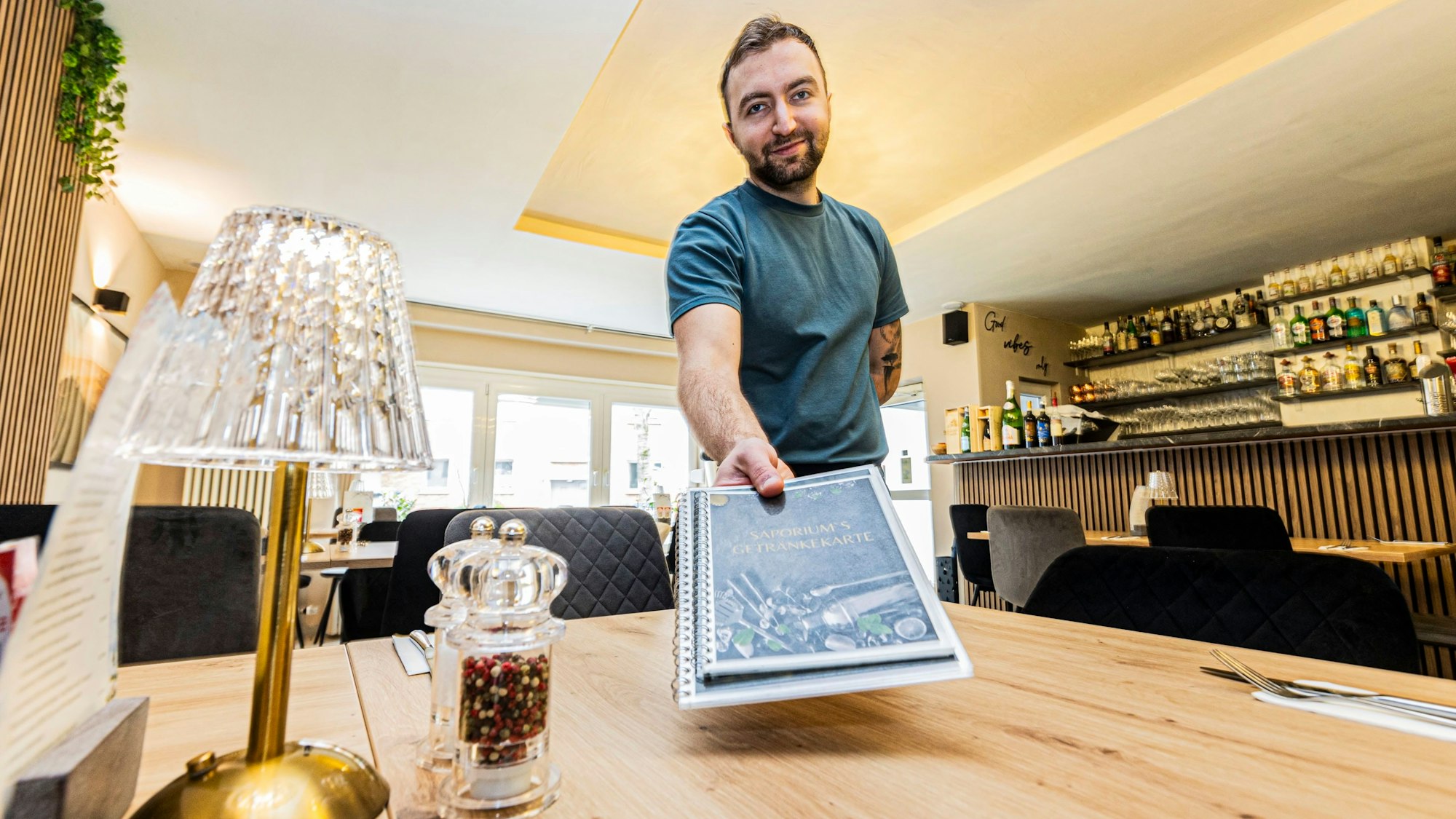 Edison Gjokla zeigt die Speisekarte im neuen Restaurant „Saporium“.