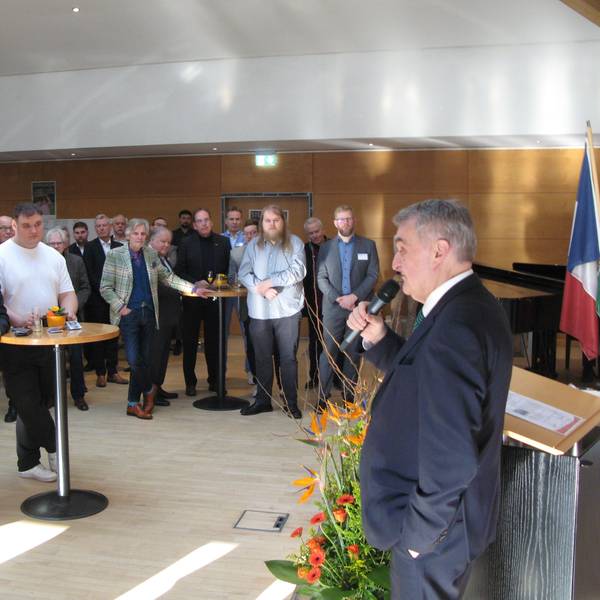 Innenminister Herbert Reul spricht vor einer Schar von Menschen in einem Saals ins Mikrofon.