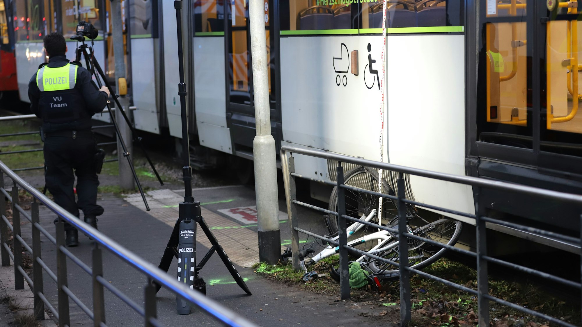 Ein Fahrrad liegt unter einer Straßenbahn. Eine Straßenbahn hat am Montagmorgen in Köln eine 17-jährige Radfahrerin erfasst. Das Mädchen trägt schwere Kopfverletzungen davon.