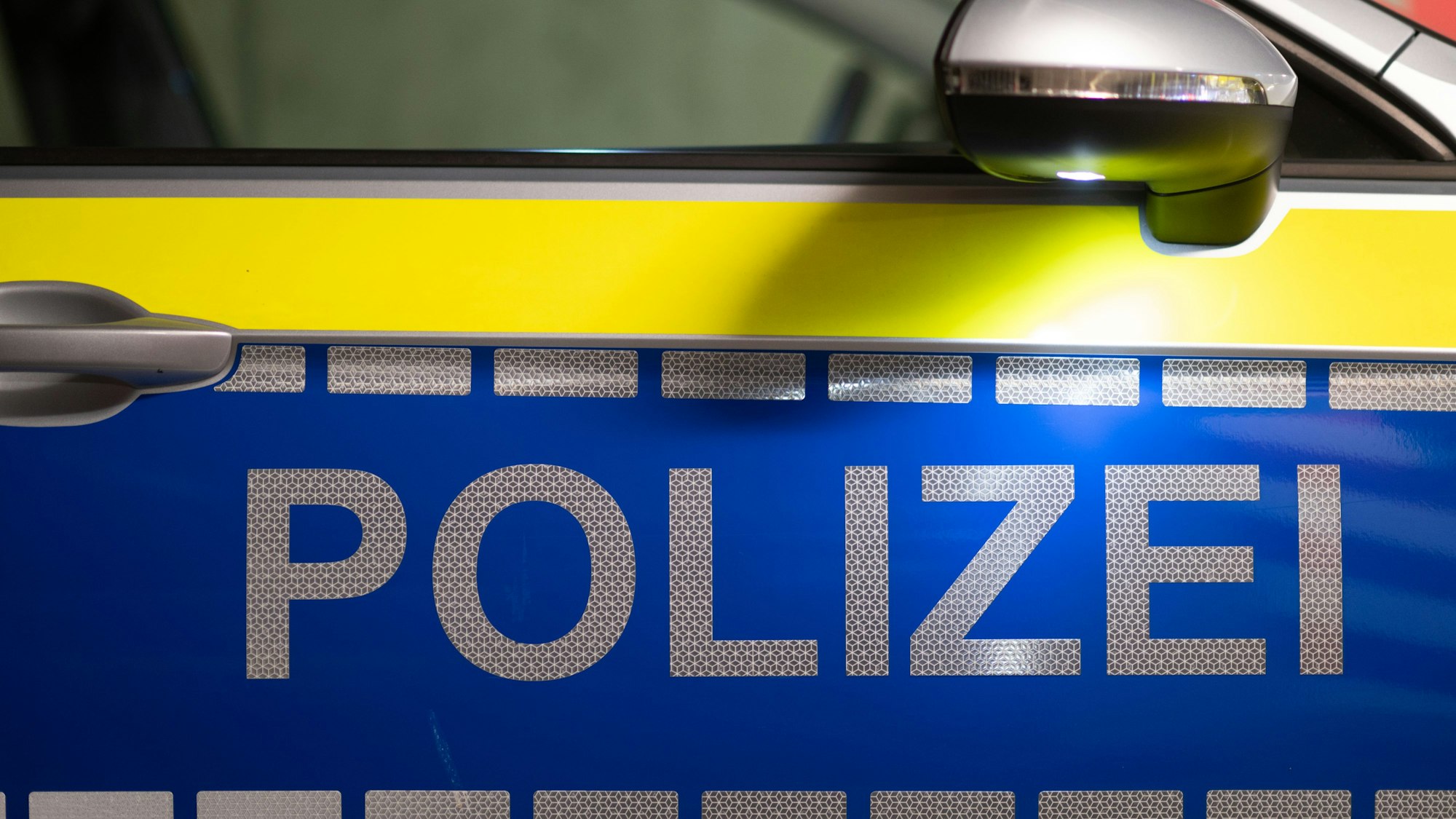 „Polizei“ ist auf der Tür eines Polizeiautos zu lesen.