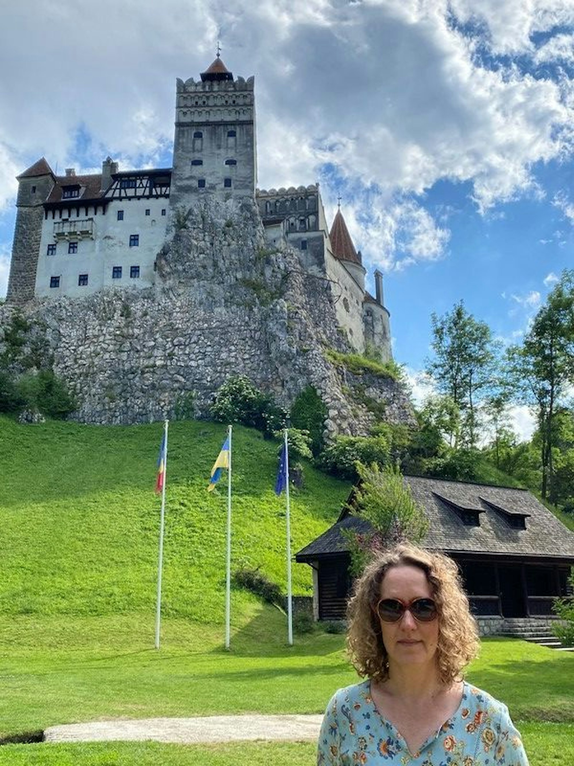 Eine Frau steht vor einem Hügel, auf dem eine Burg thront.