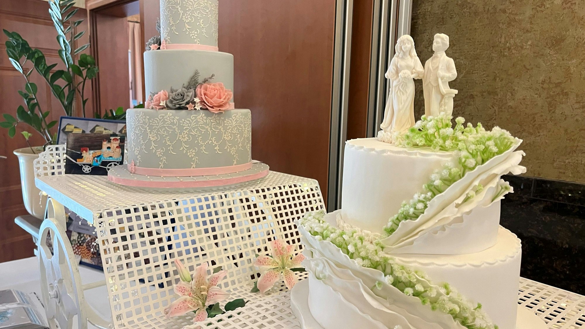 Zwei mehrstöckige Hochzeitstorten mitstilisiertem Paar on top.