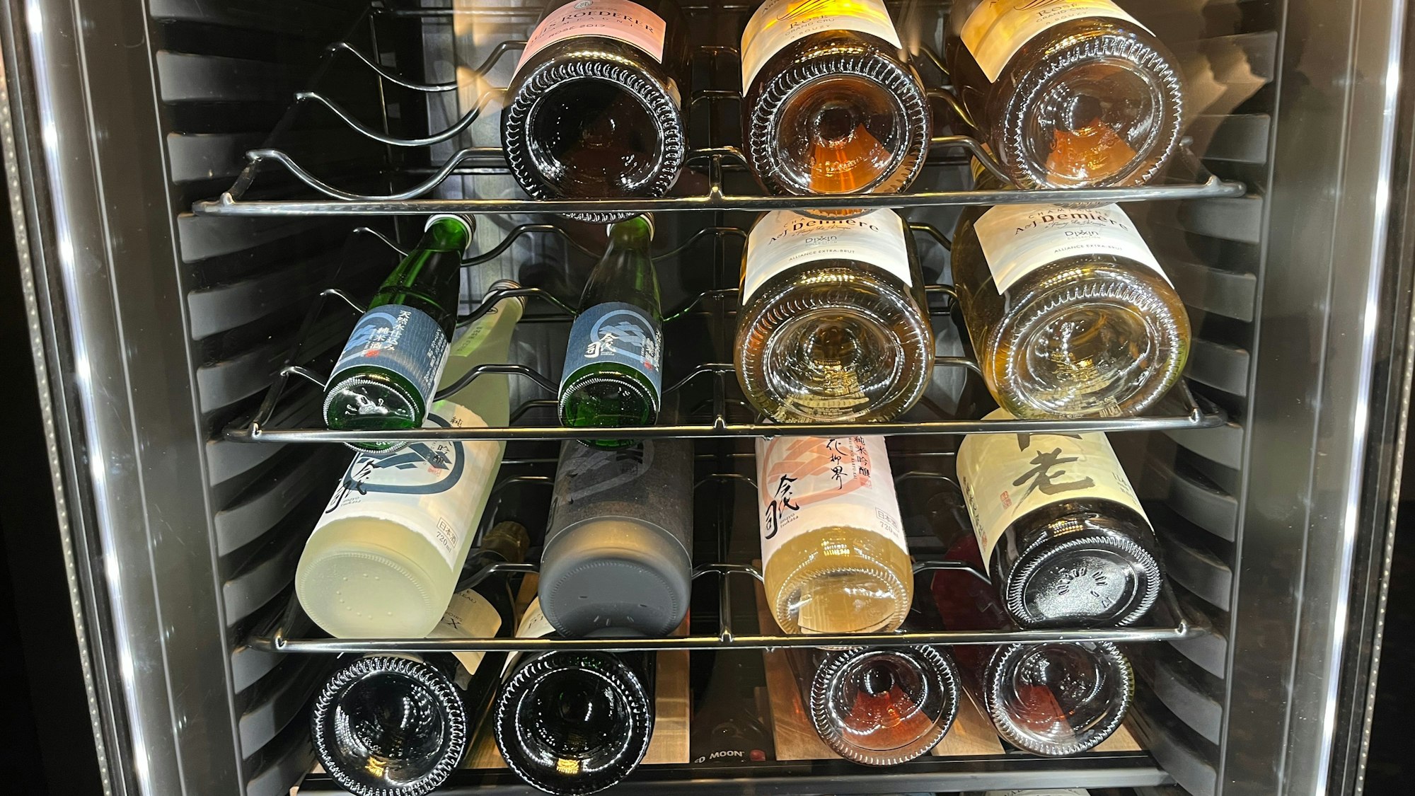 Hinter Glasscheiben liegen zahlreiche Weinflaschen.