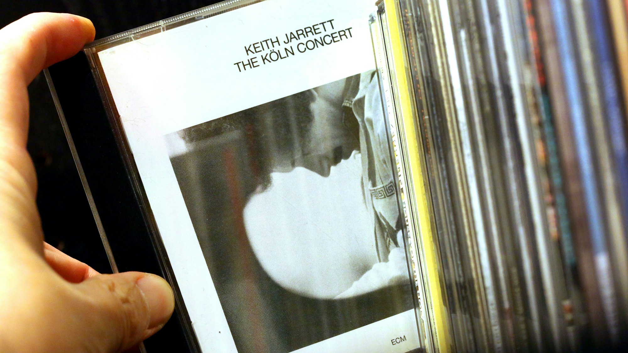 ARCHIV - 14.01.2015, Nordrhein-Westfalen, Köln: Ein Mann nimmt am 15.01.2015 in Köln (Nordrhein-Westfalen) die CD "The Köln Concert" von Keith Jarrett aus dem Regal. Mit dem «Köln Concert» hat Keith Jarrett vor 40 Jahren die Tür zum Jazz für viele neue Fans aufgestoßen. Foto\ Oliver Berg/dpa +++(c) dpa - Bildfunk+++ (zu dpa: «Wie ein Jazz-Konzert legendär wurde») Foto: Oliver Berg/dpa +++ dpa-Bildfunk +++