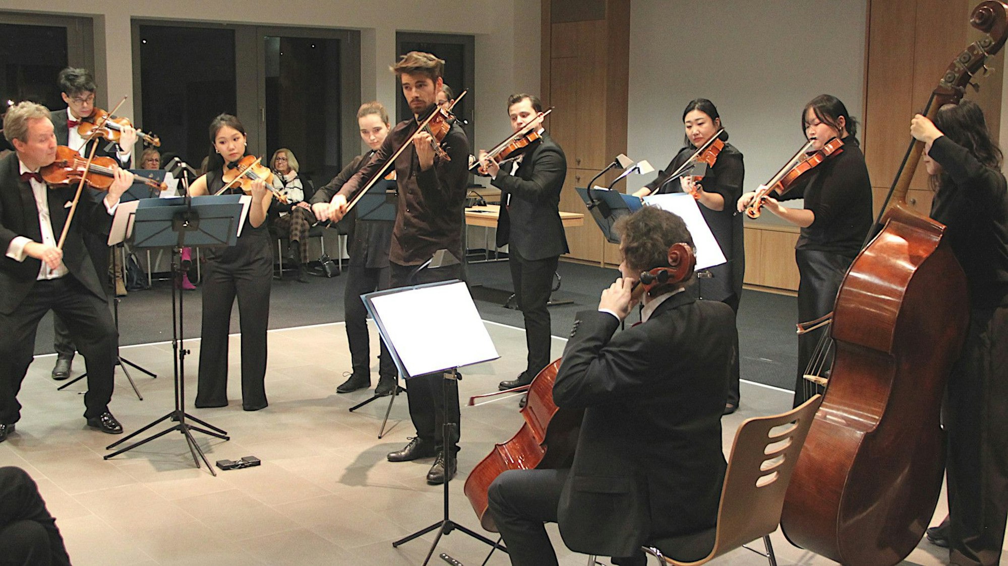 Im Ratssaal der Stadt Mechernich stehen und sitzen die Musiker der Mainzer Musici und spielen diverse Streichinstrumente.