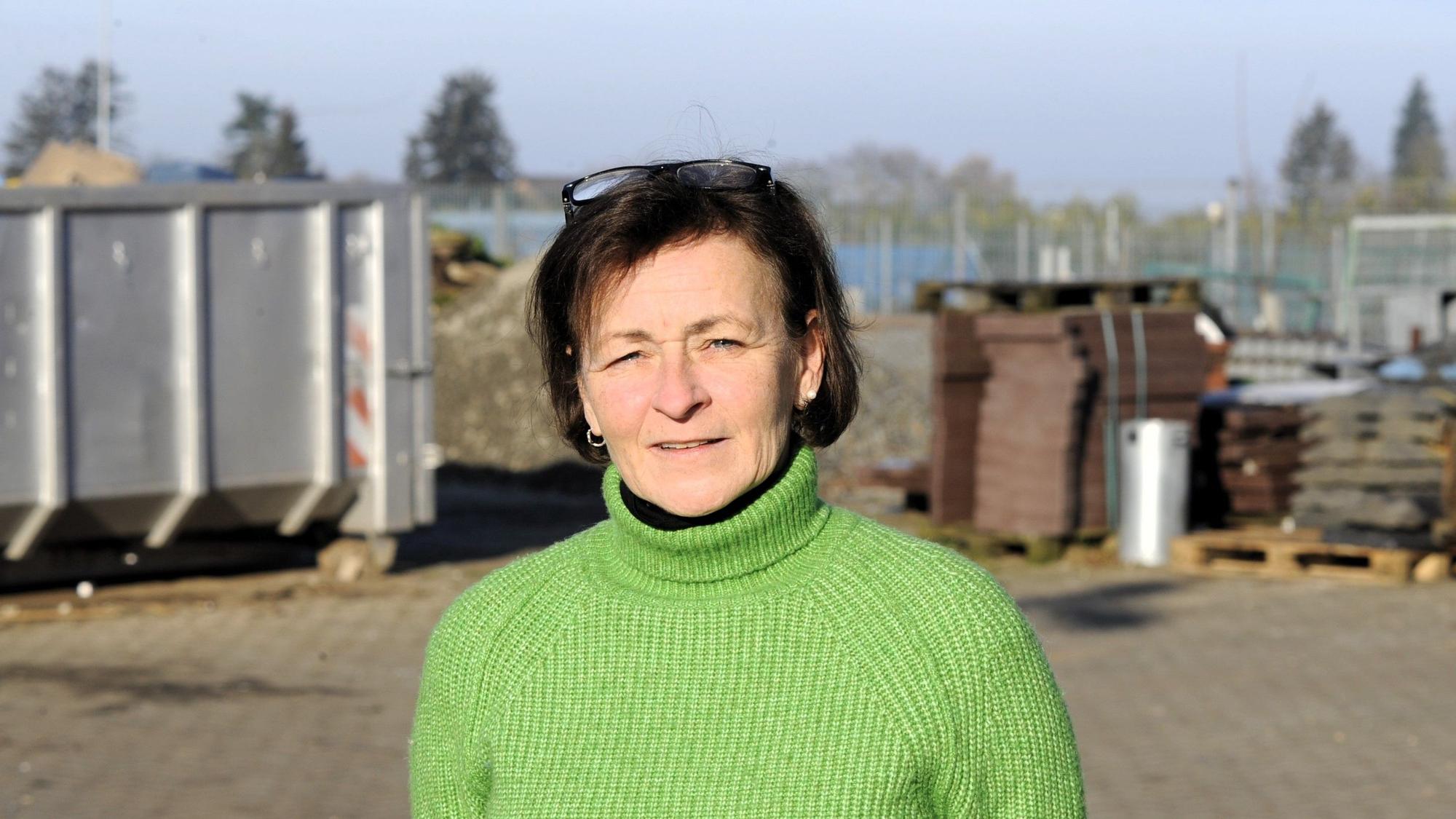 Zu sehen ist eine dunkelhaarige Frau in einem grünen Pullover.