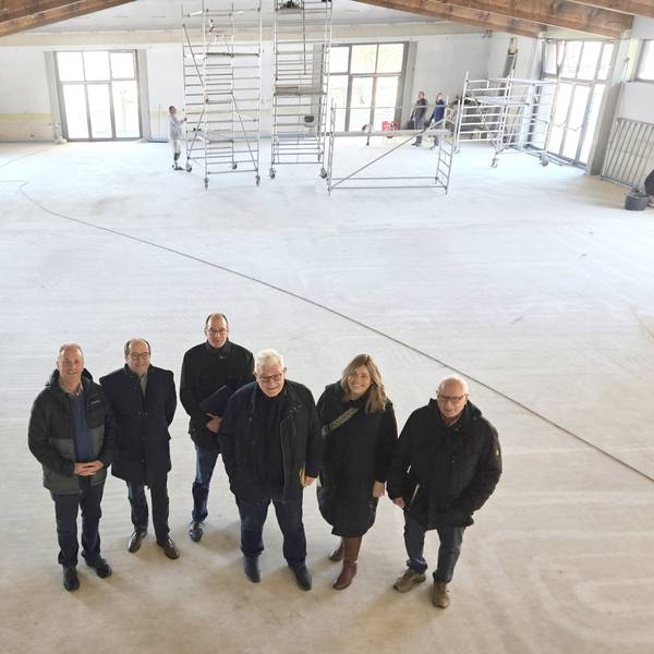 Hermann-Josef Esser, Stefan Kupp, Lothar Schatten, Gottfried Schnitzler, Nadine Schwendtner und Alois Poth vom Bürgerverein stehen in der leeren Halle, im Hintergrund sind Gerüstwagen zu sehen.