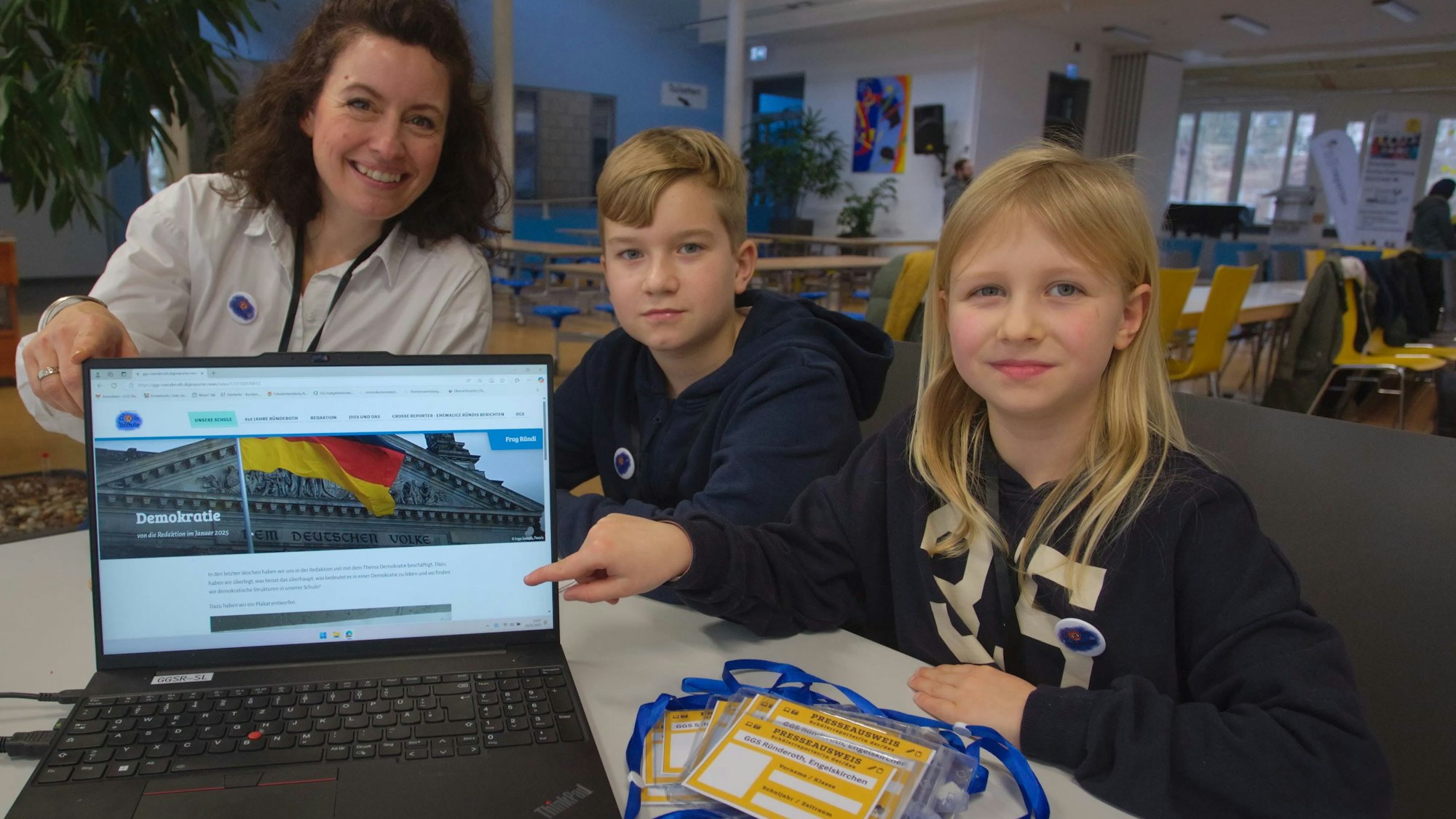 Das Projekt „digi reporter“ soll an der Gemeinschaftsgrundschule in Engelskirchen-Ründeroth auch für mehr Demokratieverständnis bei den Kindern sorgen. Die Projektbetreuerin Kerstin Nievelstein (von links) sowie die Kinder Davin und Hanna zeigen, wie es geht.