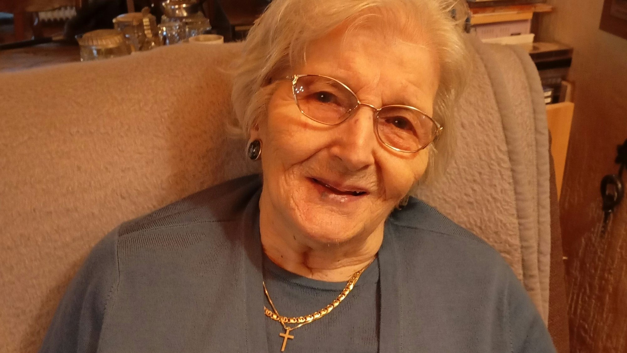 Zu sehen ist eine ältere Dame in einem Sessel.