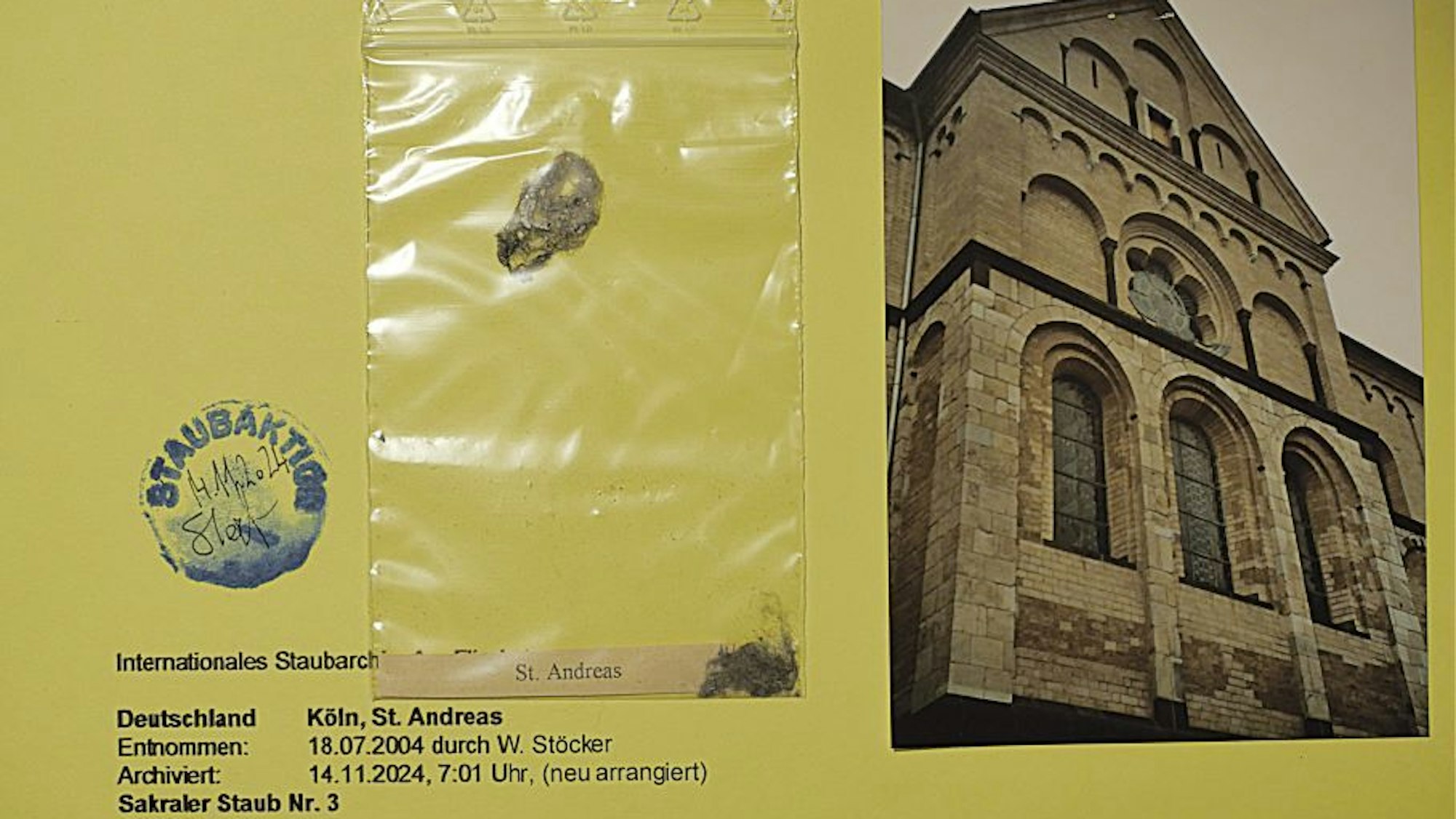 Eine eingetütete Probe aus dem Staub-Archiv von Wolfgang Stöcker. Daneben liegt eine Fotografie von der Kölner Kirche St. Andreas.