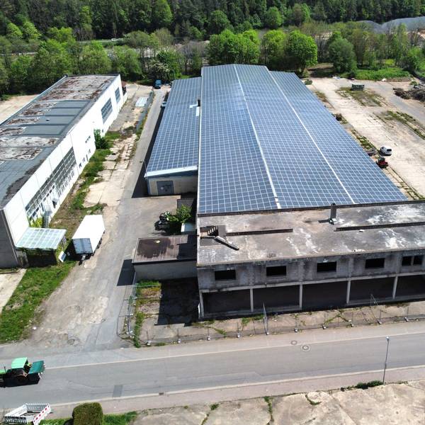 Blick auf die Milz-Hallen aus der Vogelperspektive. Auf dem Dach ist eine große Solaranlage zu sehen.