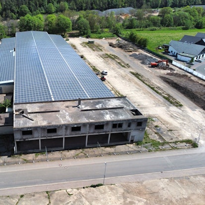 Blick auf die Milz-Hallen aus der Vogelperspektive. Auf dem Dach ist eine große Solaranlage zu sehen.