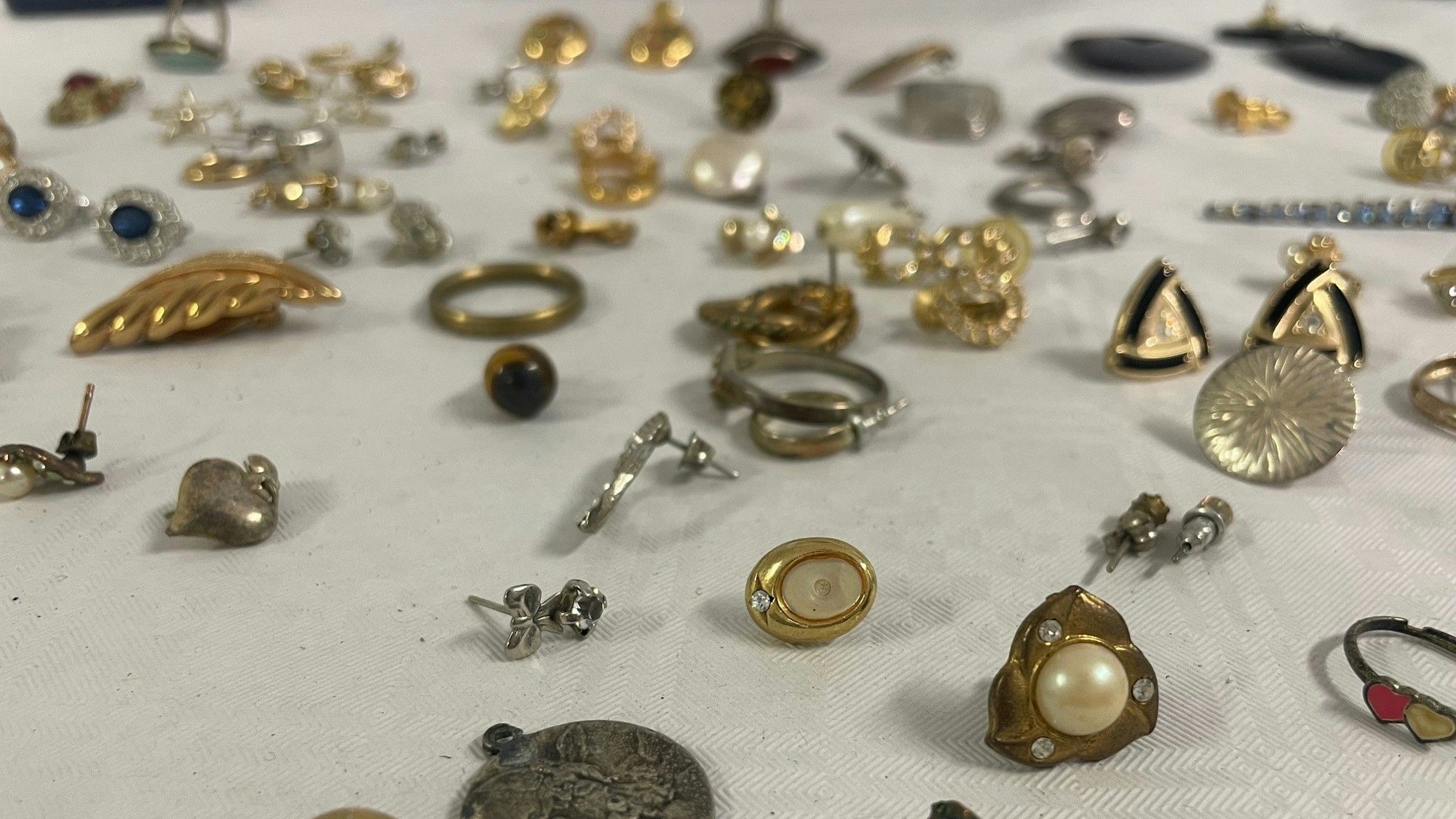 Das Bild zeigt zahlreiche Ohrringe und Broschen.