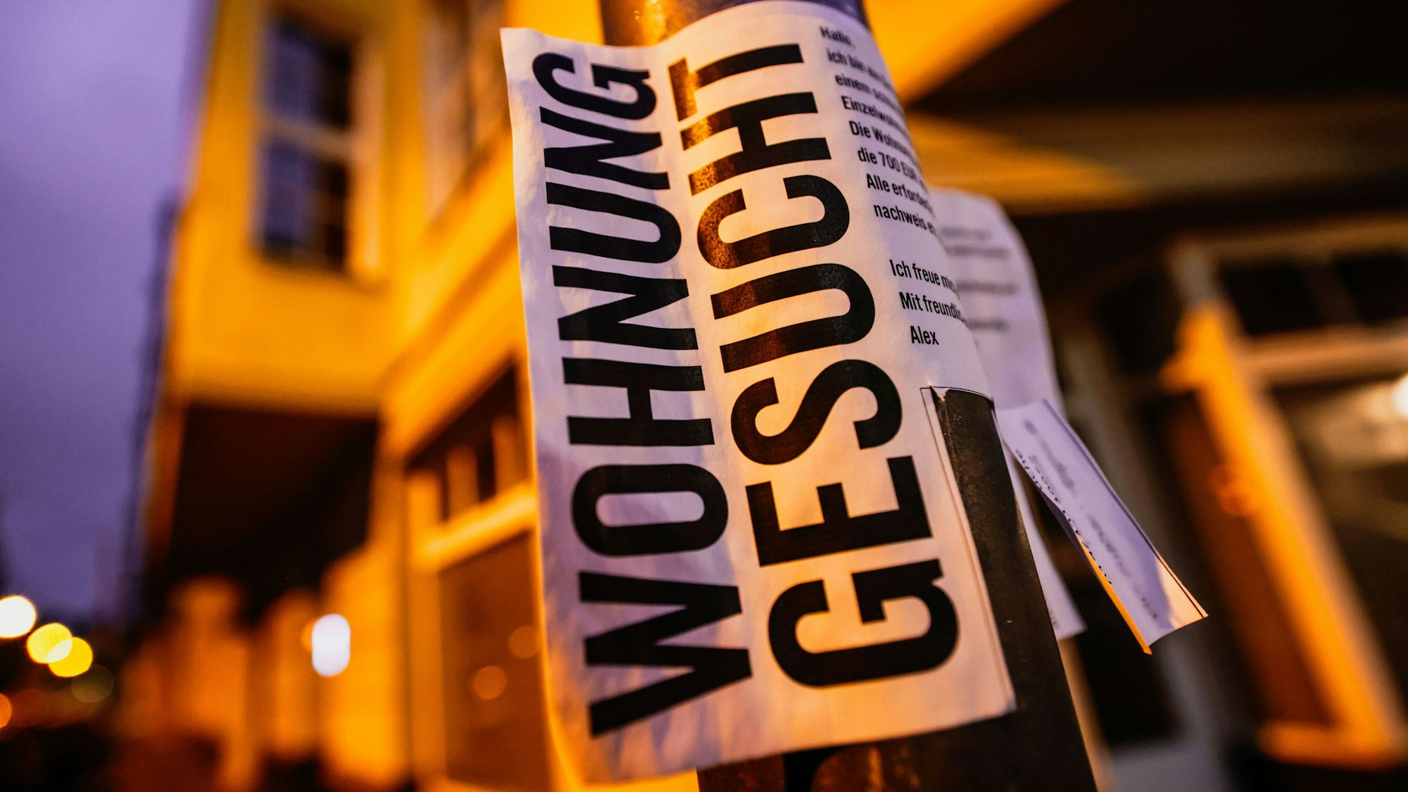 Vermieter, meldet euch: Ein Zettel für die Wohnungssuche vor Wohnhäusern in Köln.