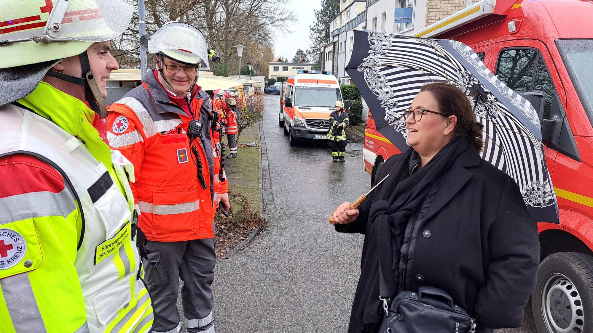 Rösraths Bürgermeisterin Bondina Schulze steht mit zwei DRK-lern an der einsatzstelle beim Brand eines Gewerbetriebs am Pestalozziweg.