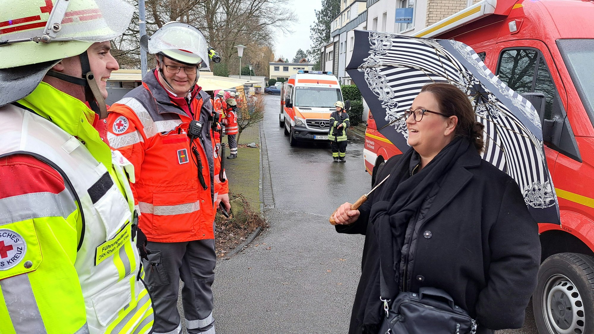 Rösraths Bürgermeisterin Bondina Schulze steht mit zwei DRK-lern an der einsatzstelle beim Brand eines Gewerbetriebs am Pestalozziweg.