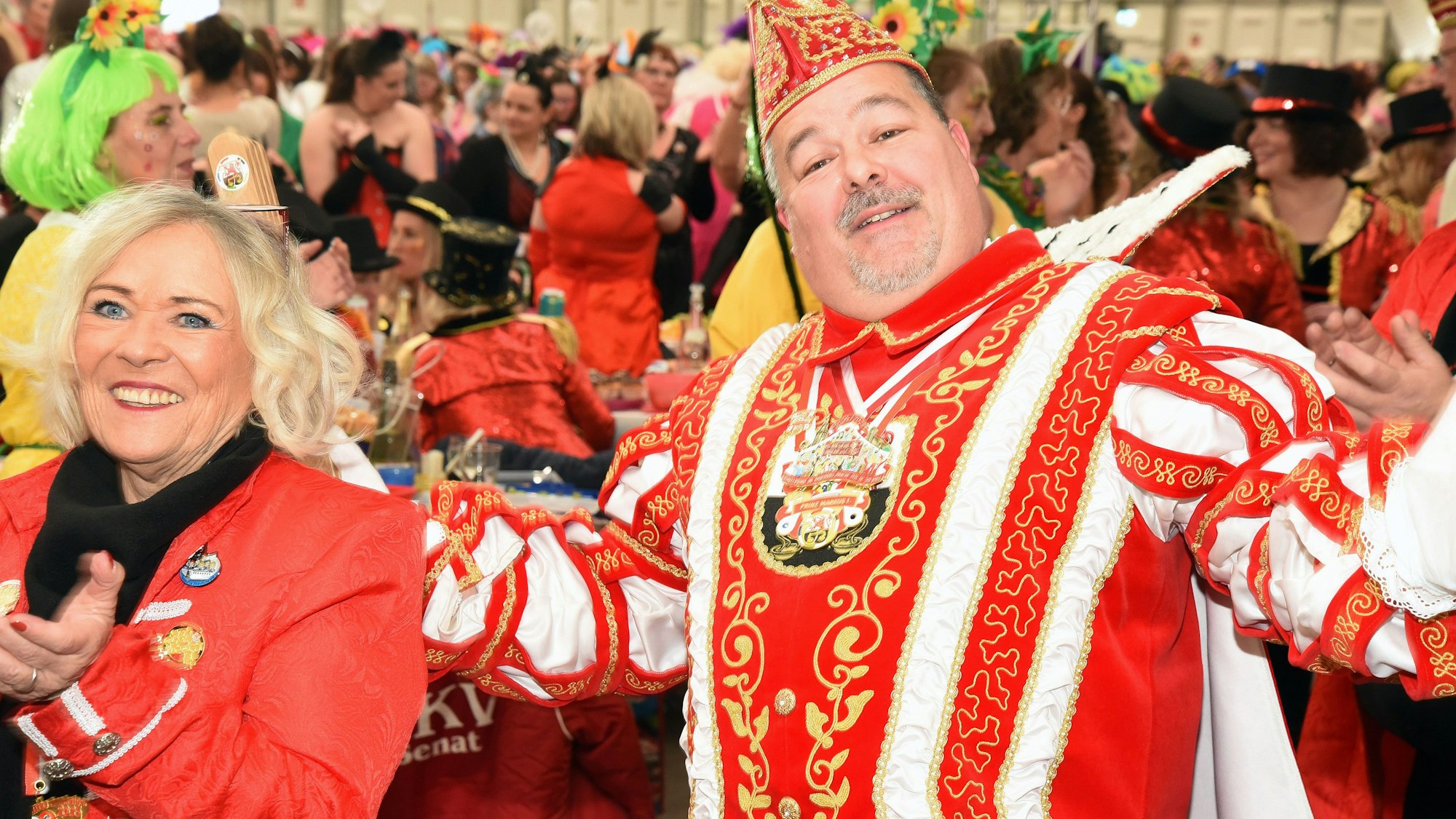 Ein Karnevalsprinz feiert bei einer Damensitzung in der Menge.