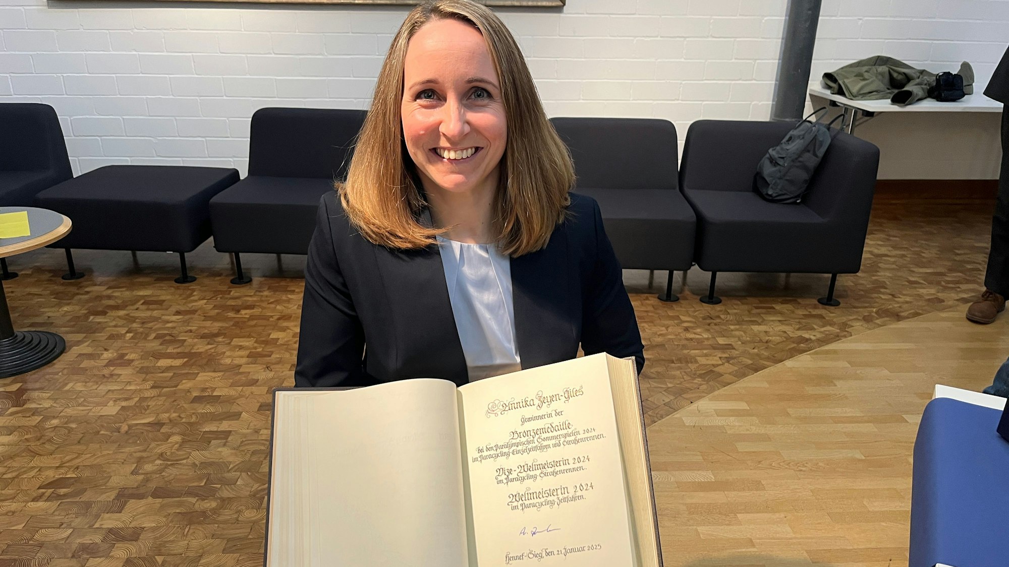 Eine Frau hält das Goldene Buch der Stadt Hennef in Händen.