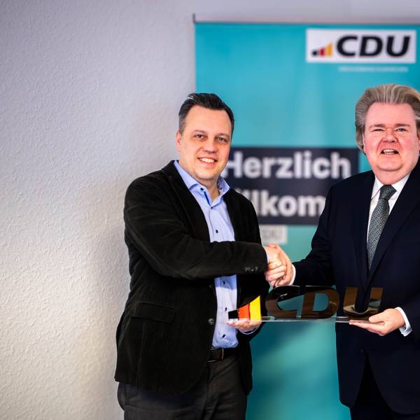 Das Bild zeigt Sacha Reichelt und Klaus Voussem, die die Zusammenarbeit mit einem Handschlag besiegeln