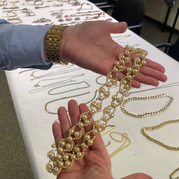 Das Bild zeigt eine Beamtin, die auf den Innenseiten ihrer Hände eine Goldkette präsentiert.