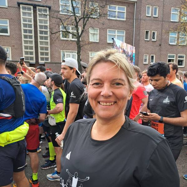Ilona Schaffrath steht im Starterfeld einer Laufveranstaltung und lacht in die Kamera.