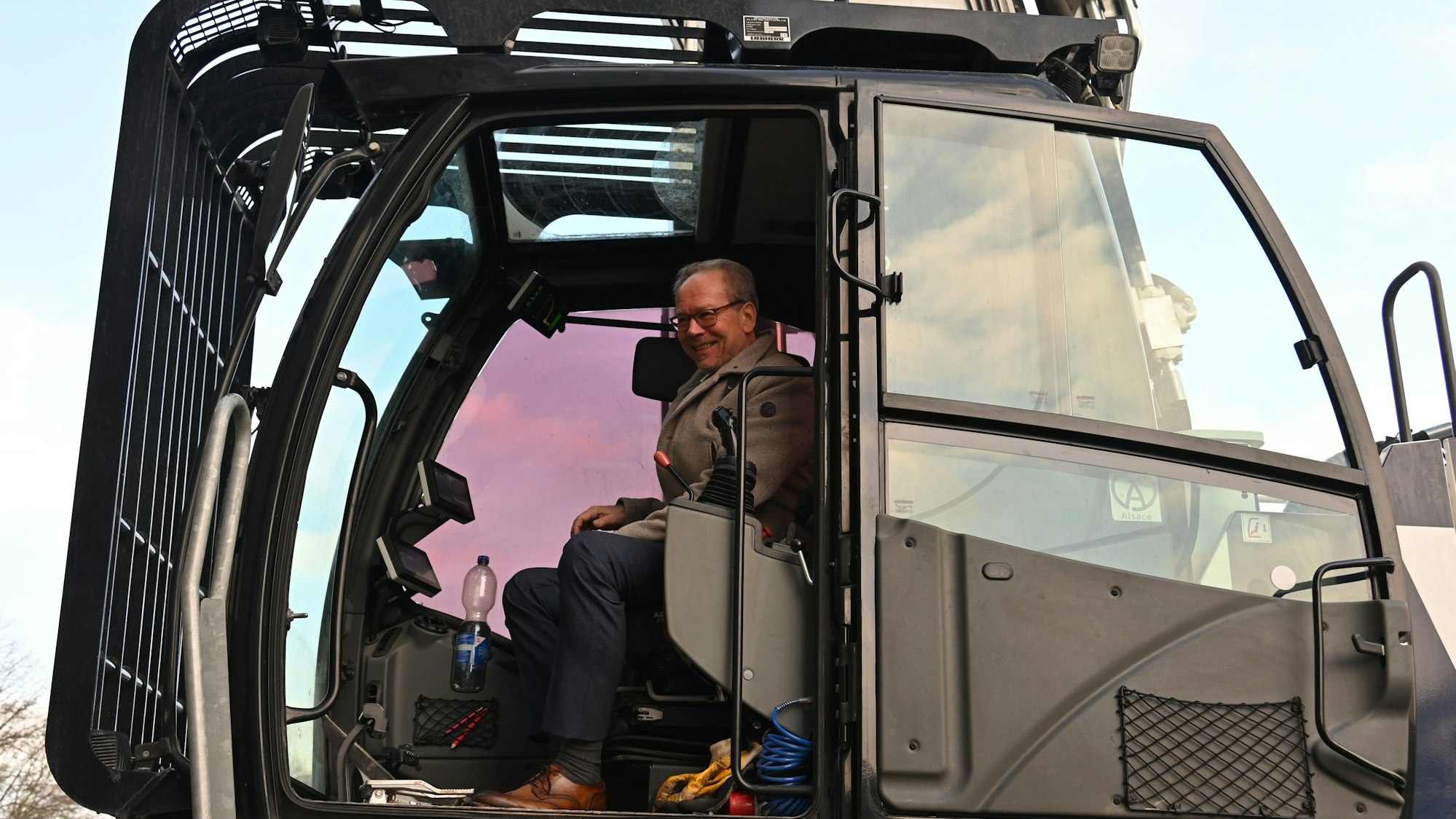 Zu sehen ist Bergheims Bürgermeister Volker Mießeler in einem Bagger.