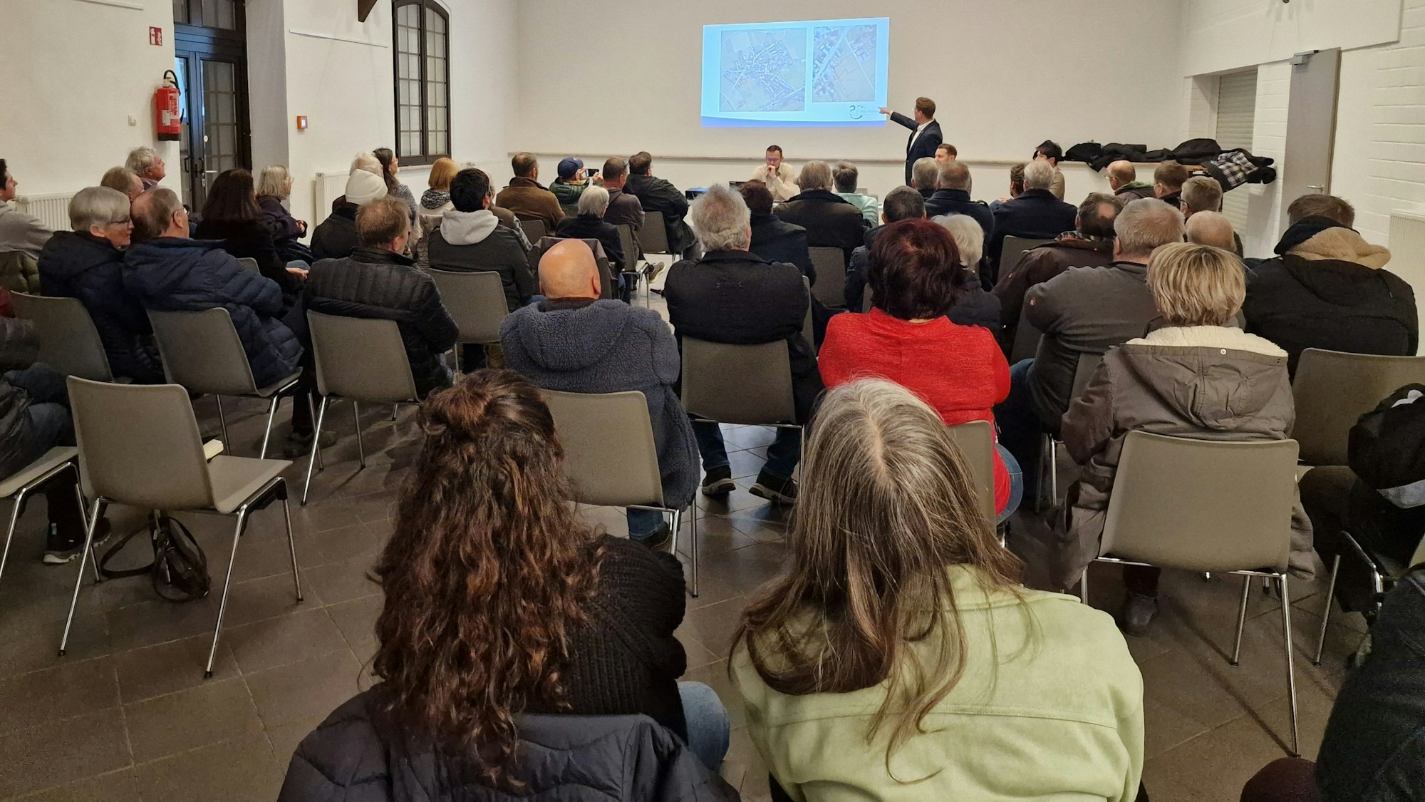 Der erste Beigeordnete, Swen Christian, erläutert vor rund 60 Bürgern das Vorhaben, 8 Tiny-Häuser für Flüchtlingsfamilien an der Gimmerdorfer Milchgasse aufzustellen