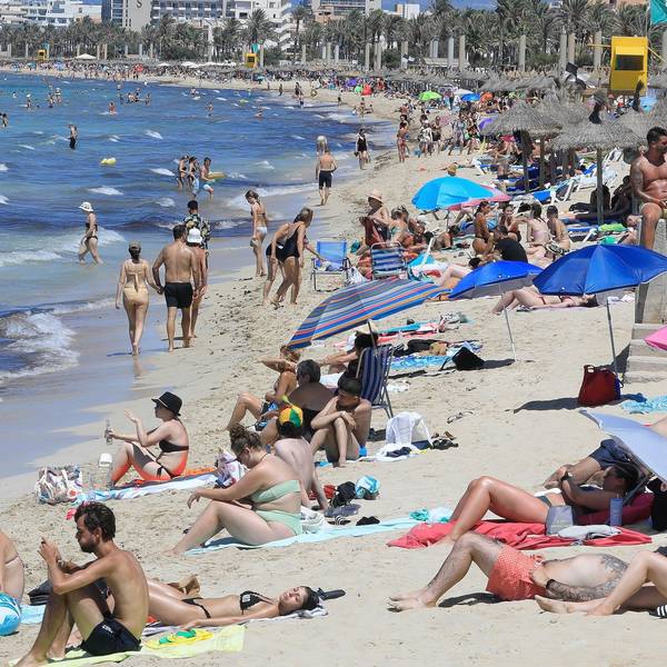 24.07.2024, Spanien, Palma: Touristen genießen einen warmen Sommertag am Strand von Arenal.