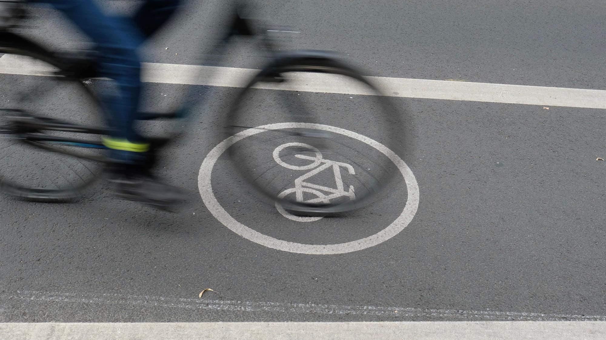 Ein Fahrradfahrer fährt auf dem Radfahrstreifen einer Fahrbahn.