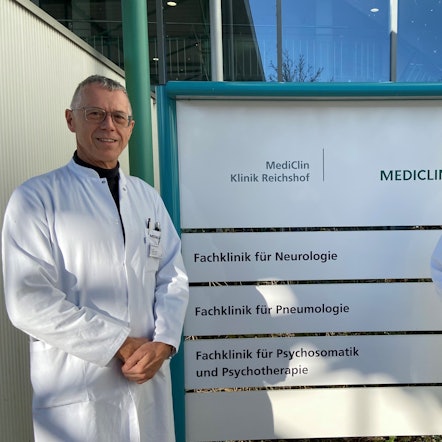 Matthias Schmalenbach, Chefarzt der Pneumologie  an der Mediclin-Rehaklinik in Reichshof-Eckenhagen, und Jürgen Bonnert, Chefarzt der Neurologie und kommissarischer Chefarzt für Psychosomatik und Psychotherapie, stehen vor einem Klinikschild.