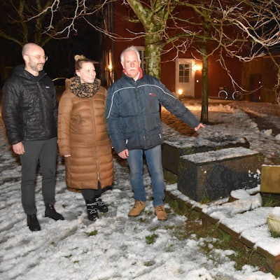 Zu sehen sind zwei Männer und eine Frau vor umgeworfenen Grabsteinen.