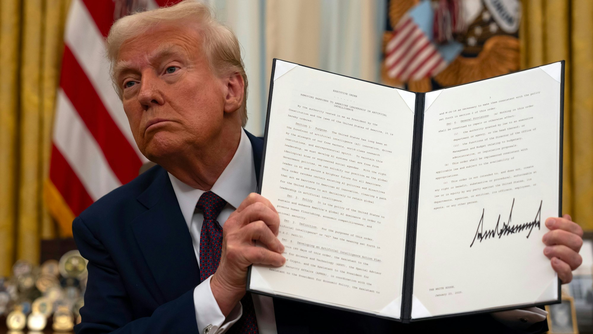 US-Präsident Donald Trump hält im Oval Office des Weißen Hauses eine unterzeichnete Anordnung zum Thema künstliche Intelligenz hoch.