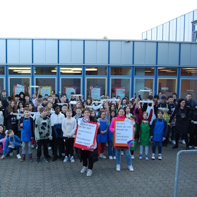 Schüler protestieren vor dem Schulgebäude.