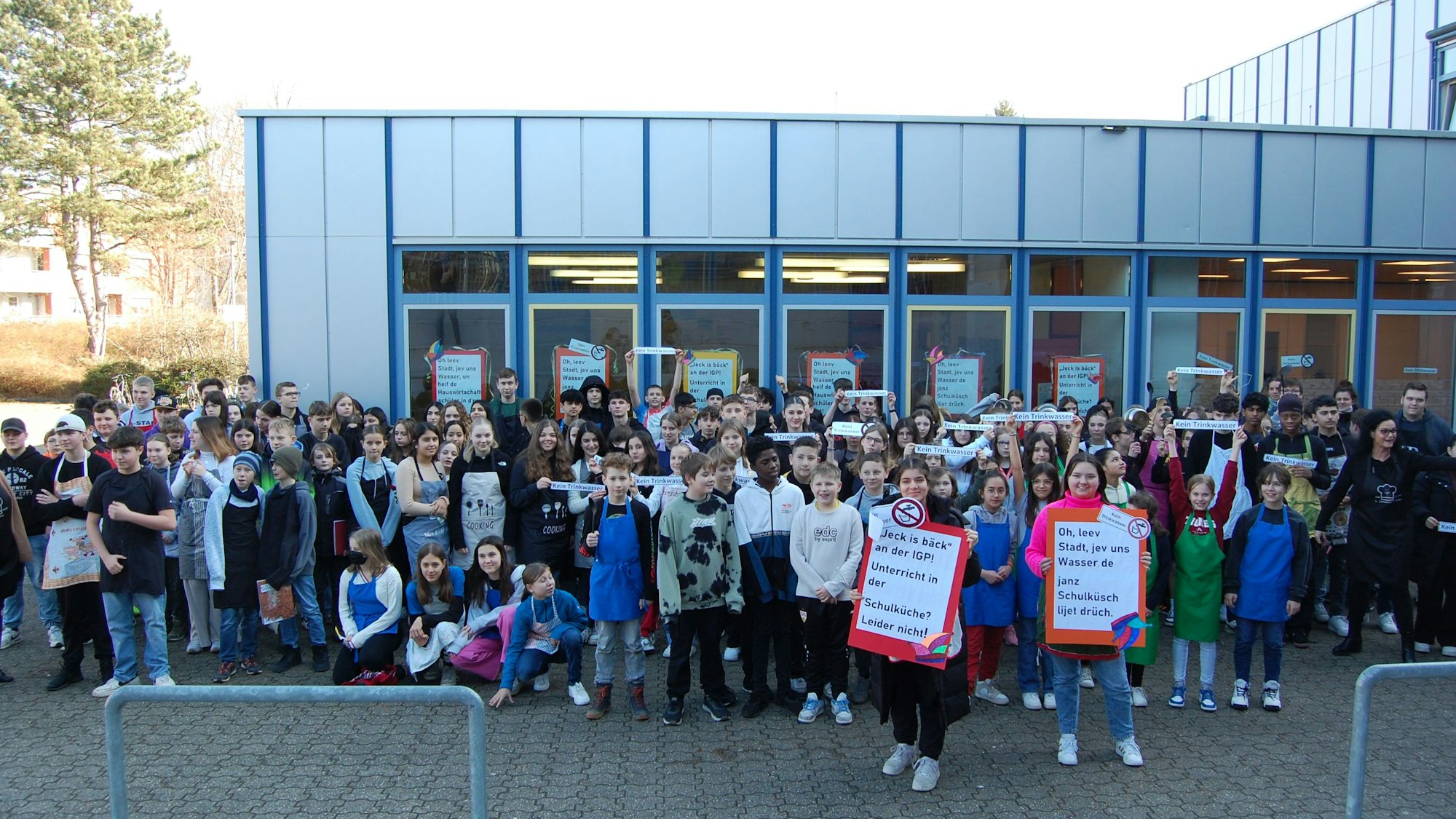 Schüler protestieren vor dem Schulgebäude.