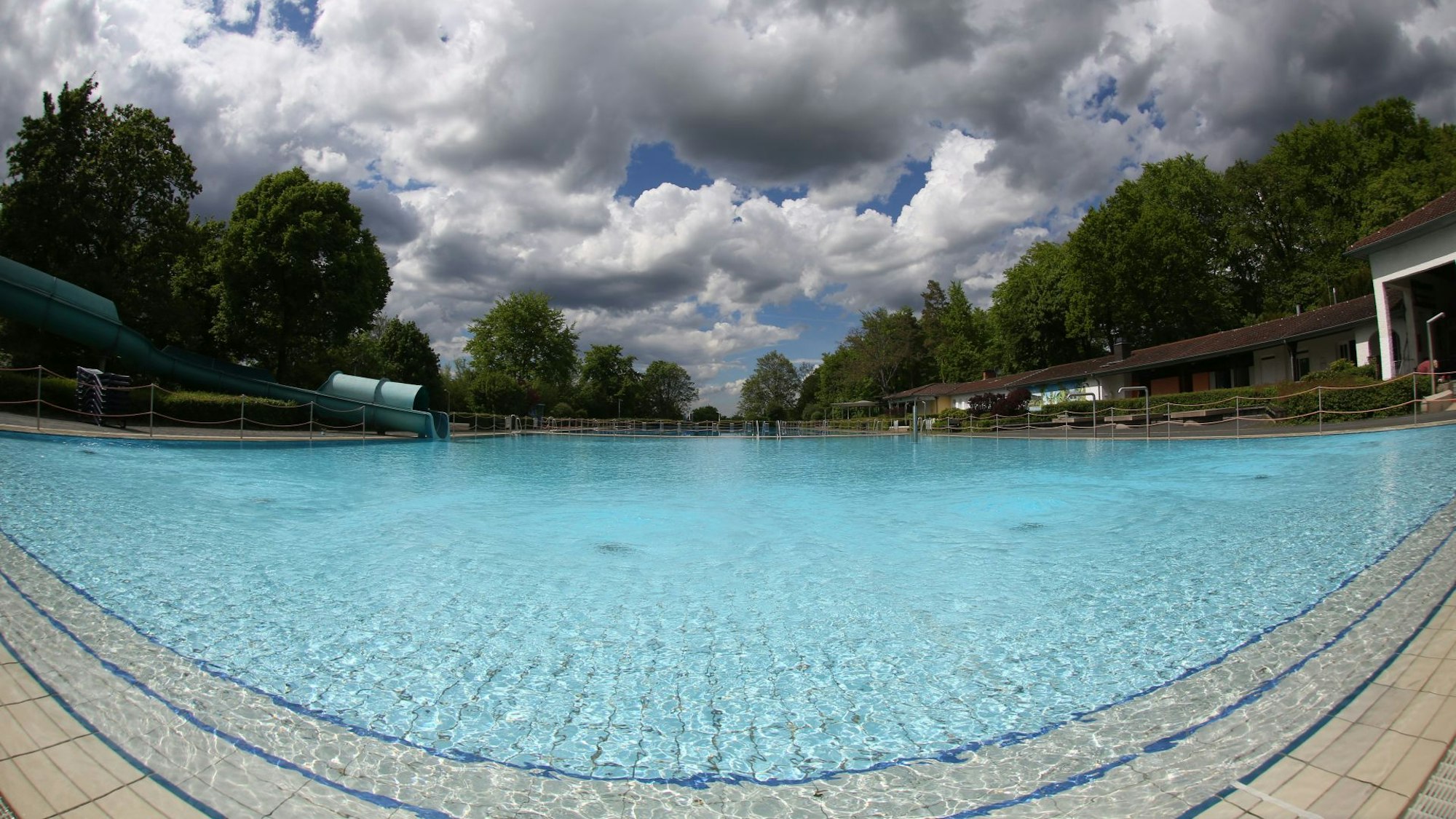 Ein großes Schwimmbecken, darüber dunkle Wolken am Himmel