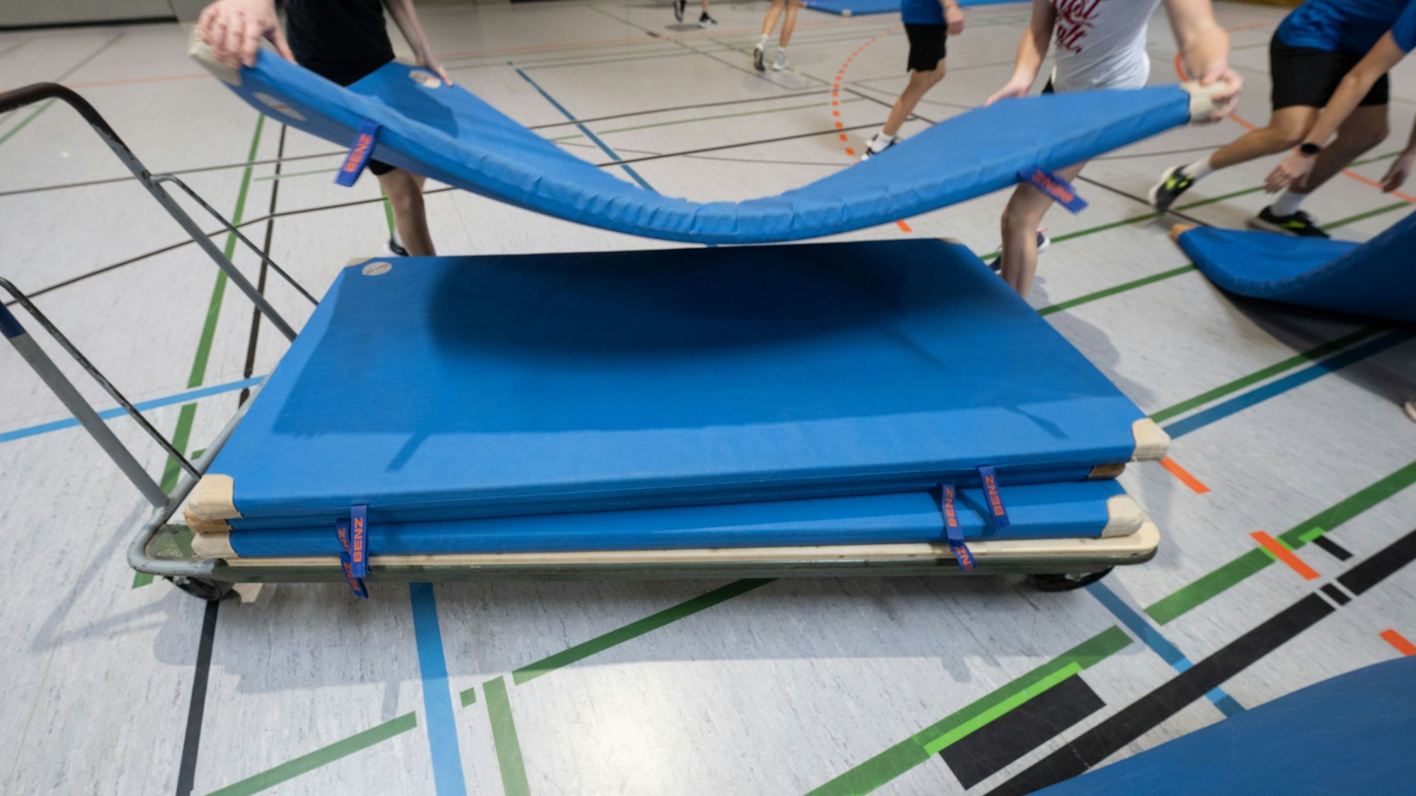 Auf dem Bild ist ein Mattenwagen in einer Sporthalle zu sehen.