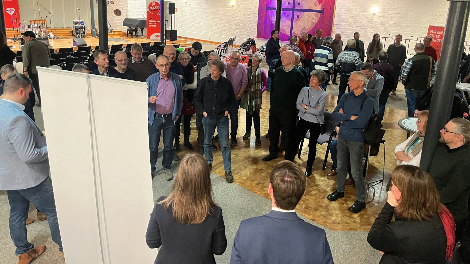 Eine Gruppe von Menschen steht zusammen und diskutiert.