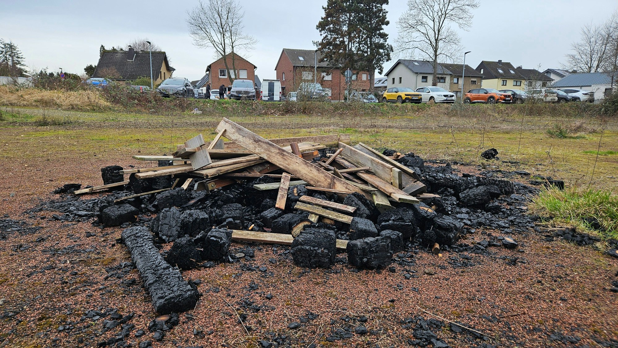 Auf dem Bild ist ein Haufen alter Bretter, die zum Teil verbrannt sind, zu sehen.