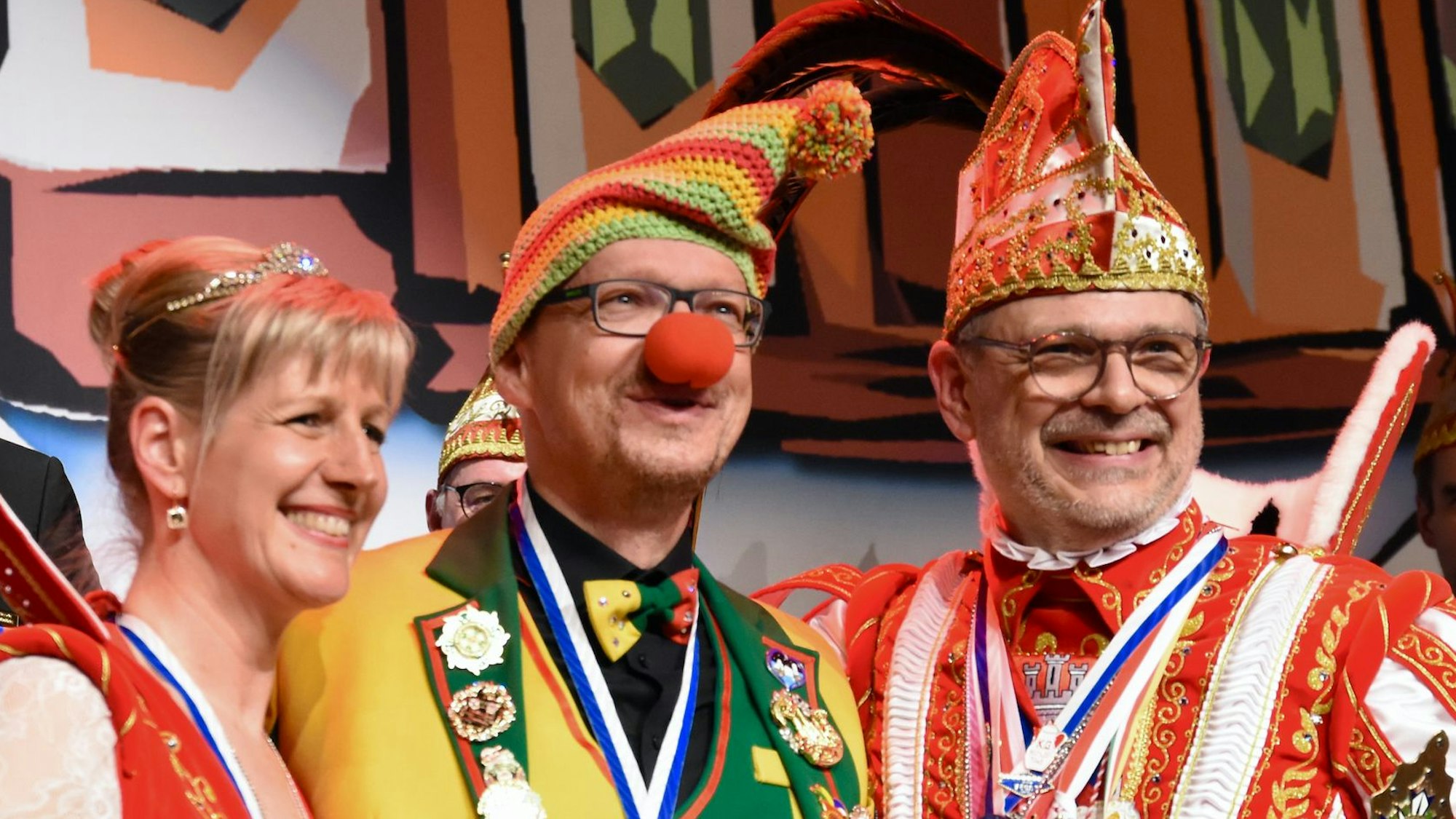 Eine Frau und zwei Männer in Karnevalskostümen.